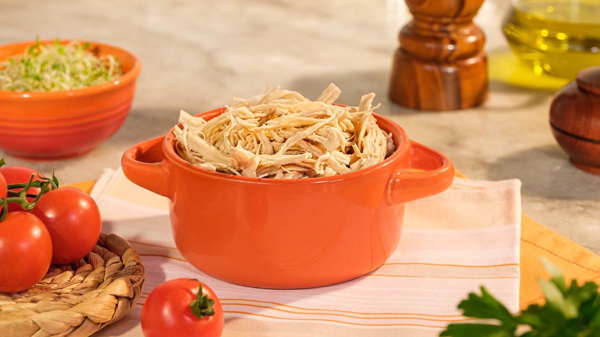 Bowl laranja com frango desfiado em destaque