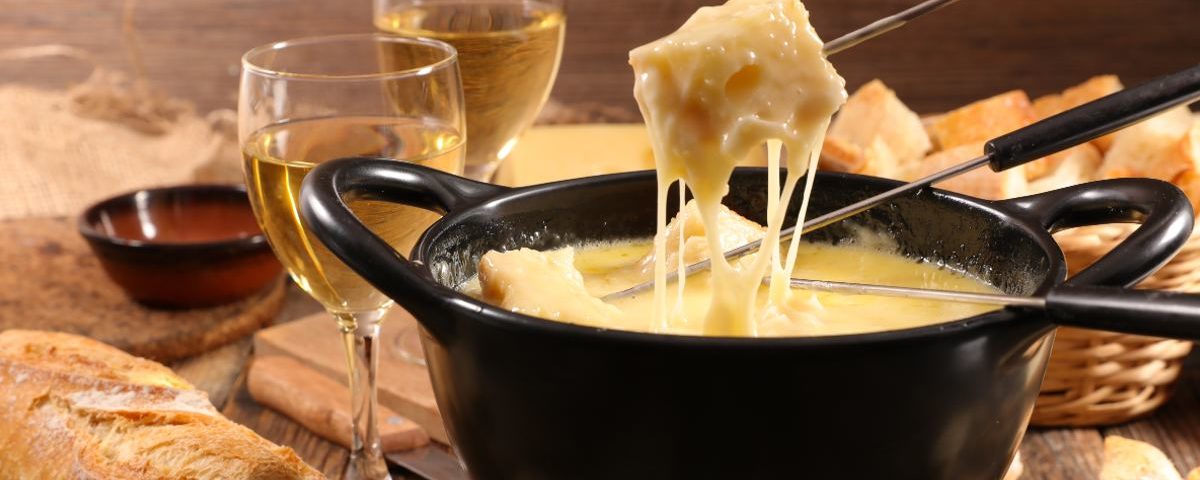 Qual a função do vinho no fondue de queijo?