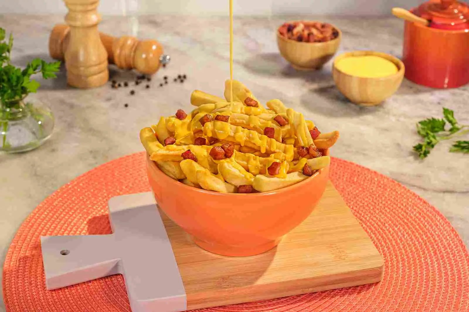 batata frita com cheddar e bacon encima da tábua em uma mesa com molhos e tempero em volta