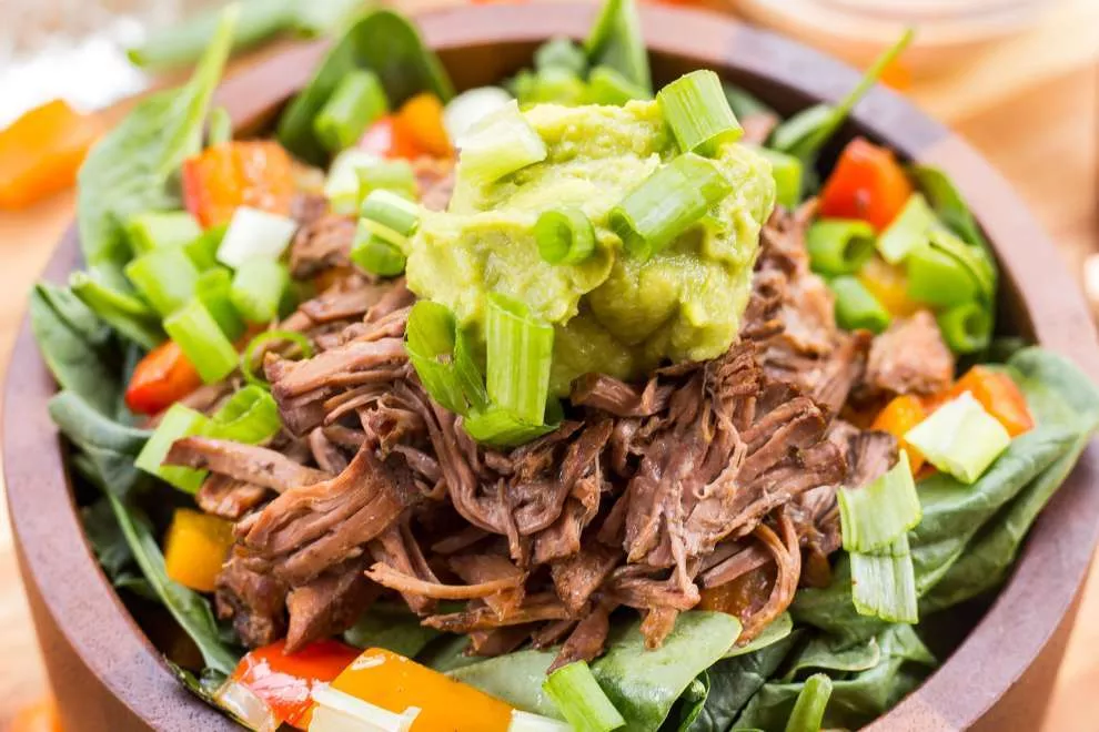 Salada de carne louca de lagarto em uma tigela de madeira