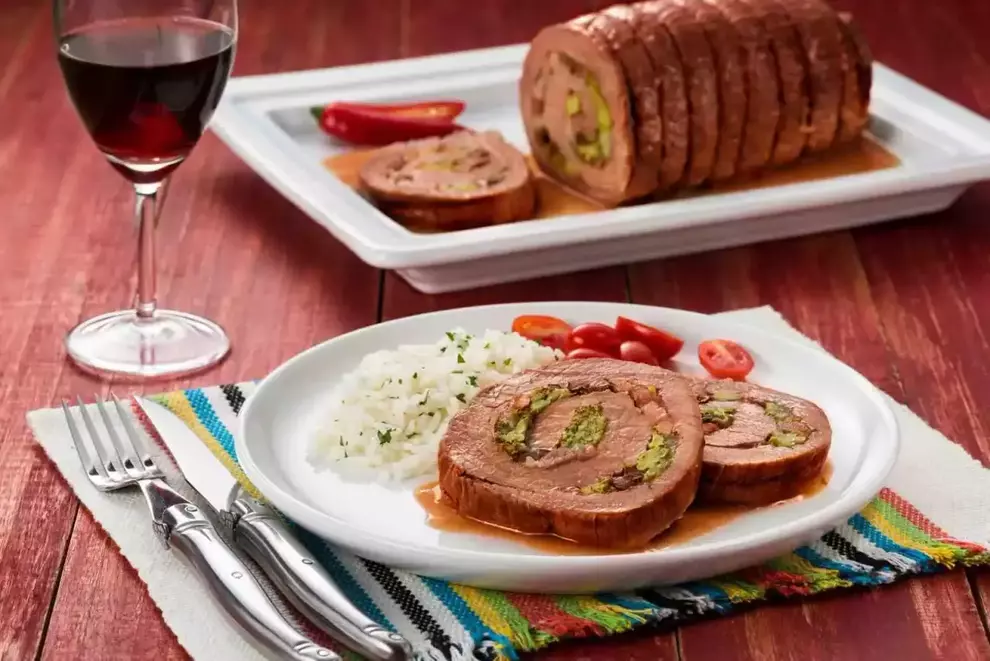 rocambole com arroz e tomates com uma taça de vinho ao lado