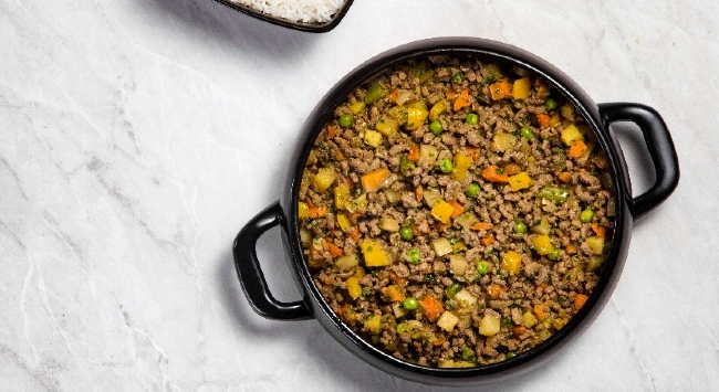 Carne moída refogada com legumes na panela.