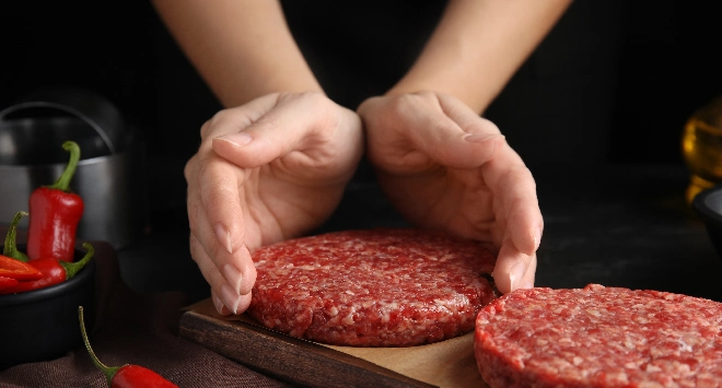 Mão moldando um hambúrguer caseiro de carne bovina