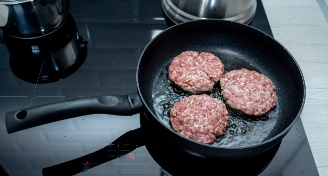 Hambúrgueres caseiros fritando em uma frigideira