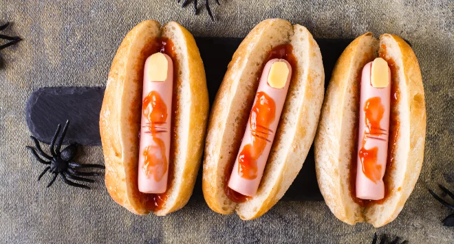 Hot dog de halloween servido em uma mesa simples com aranhas de decoração