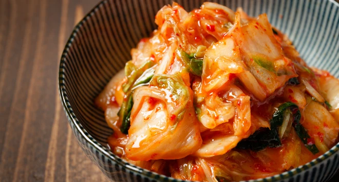 Kimchi servido em uma tigela litrada azul e branca.