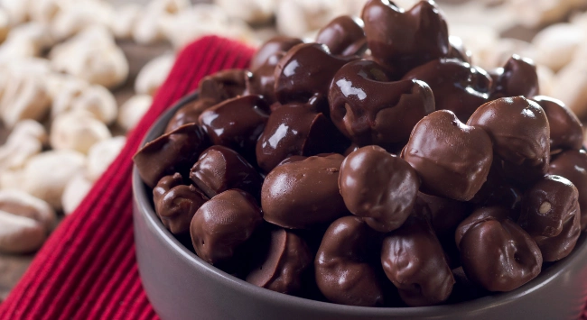 Pipoca doce coberta com chocolate servida em uma tigela cinza.