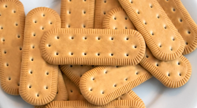 Biscoitos tipo maizena dispostos em uma mesa branca.