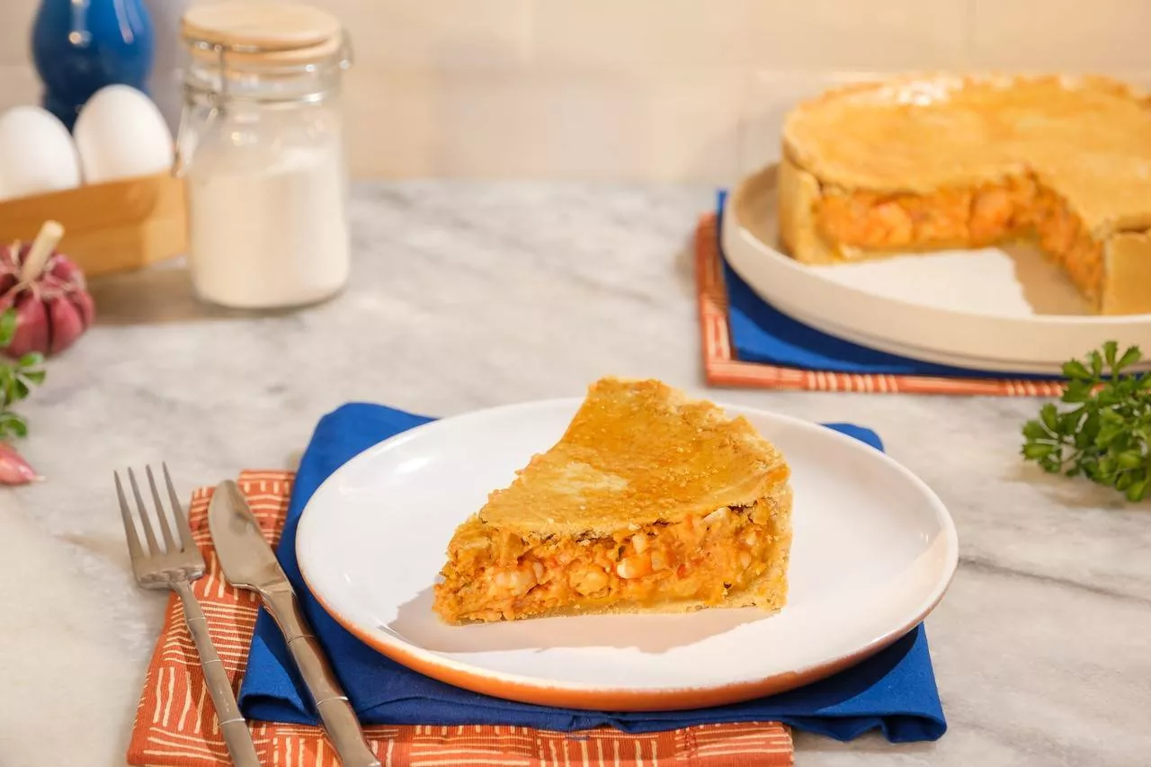 dois pratos em cima de uma mesa de marmore com uma torta de frango e talheres