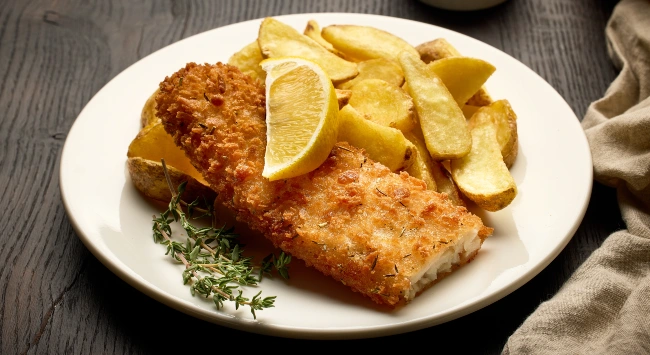 Peixe empanado sequinho e crocante, servido com batata e limão.